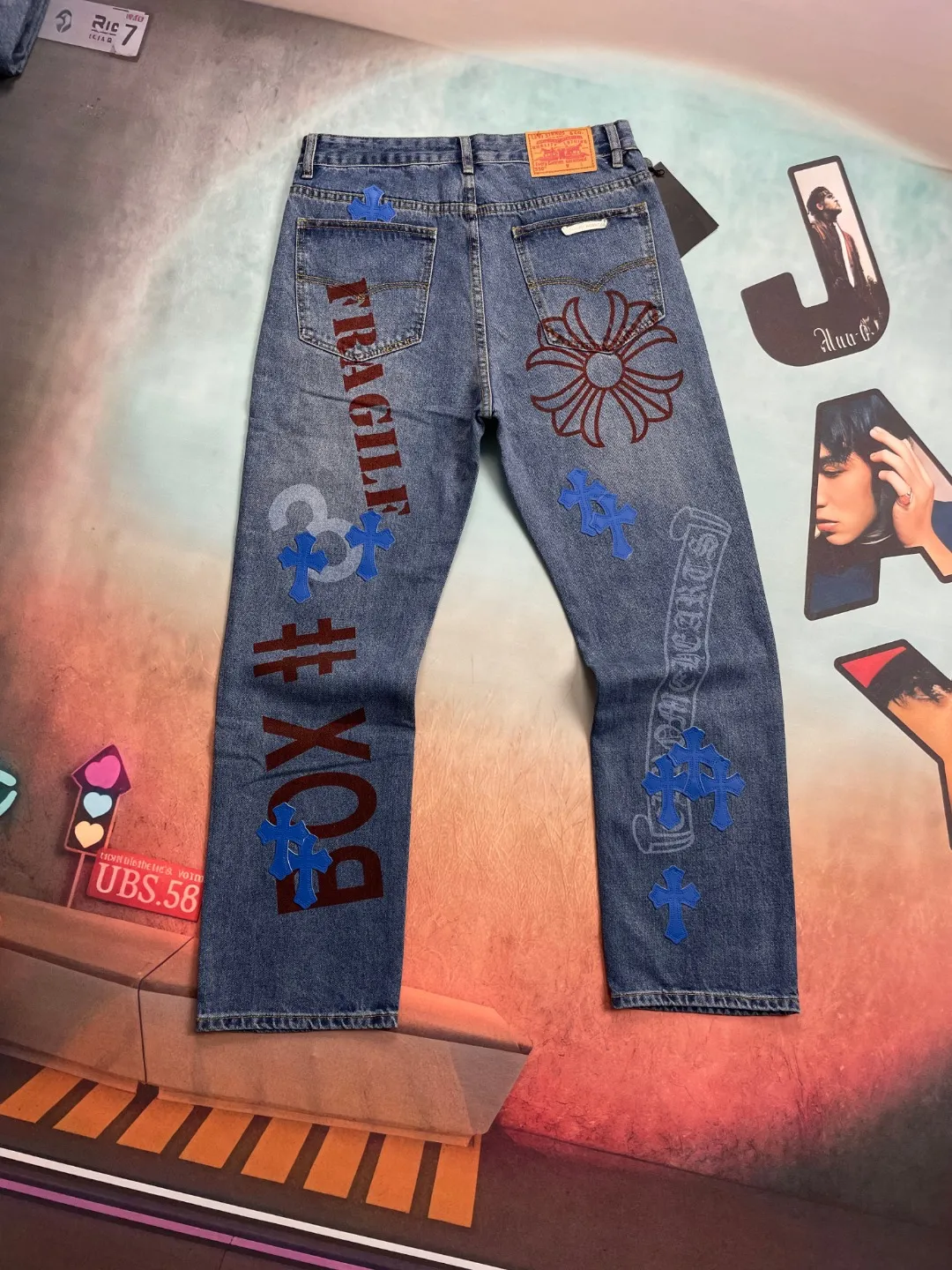 🅿️280 🔘Style No.-KL135 🔘Cro Heart𝐂𝐡𝐫𝐨𝐦𝐞 𝐇𝐞𝐚𝐫𝐭 Sanskrit limited edition graffiti printed cross patch leather jeans* These pants are unique in the selection of fabrics, using thick beaded canvas, which is inherently tough and textured. Subsequently, it undergoes heavy washing. This complex process is like casting magic on the fabric. After being put on the body, it not only feels softer to the touch, but also presents a richer and unique texture. The texture soars straight up, and you can feel its extraordinary quality every time you touch it. At the same time, the washed beaded canvas has excellent breathability. No matter when you wear it, you will never feel hot and stuffy, and you will always stay dry and comfortable. In terms of pattern design, the pants use three-dimensional cutting technology. This is not an ordinary cutting method, but an all-round and precise cutting based on the shape changes of the human body in various postures. As a result, the trousers are exceptionally tall and straight, and can perfectly fit the leg lines. Whether standing upright or walking freely, they can show a neat and cool posture, greatly modify the leg shape, and highlight the elegance of the wearer. The details highlight the high quality and unique charm of these pants. The hardware is customized from ZP. Its quality is extraordinary, its glossiness and durability are far superior to ordinary hardware. Every buckle is smooth and smooth, and it will not fade or wear out after long-term use. The customized small leather label is uniquely designed. It is a small piece of leather label, but it incorporates the designer's ingenuity. The patterns and textures on it are exquisite and delicate, highlighting the high-end tone of the brand. The workmanship of the trousers is exquisite, and every line is neatly and carefully arranged. Whether it is the trousers seam, splicing, or pocket edges, they are all handled extremely well. From the overall design to the details, they adhere to the concept of simplicity and elegance, showing the beauty of the details vividly.  Size: S M L XL (28.30.32.34) Color: Blue
